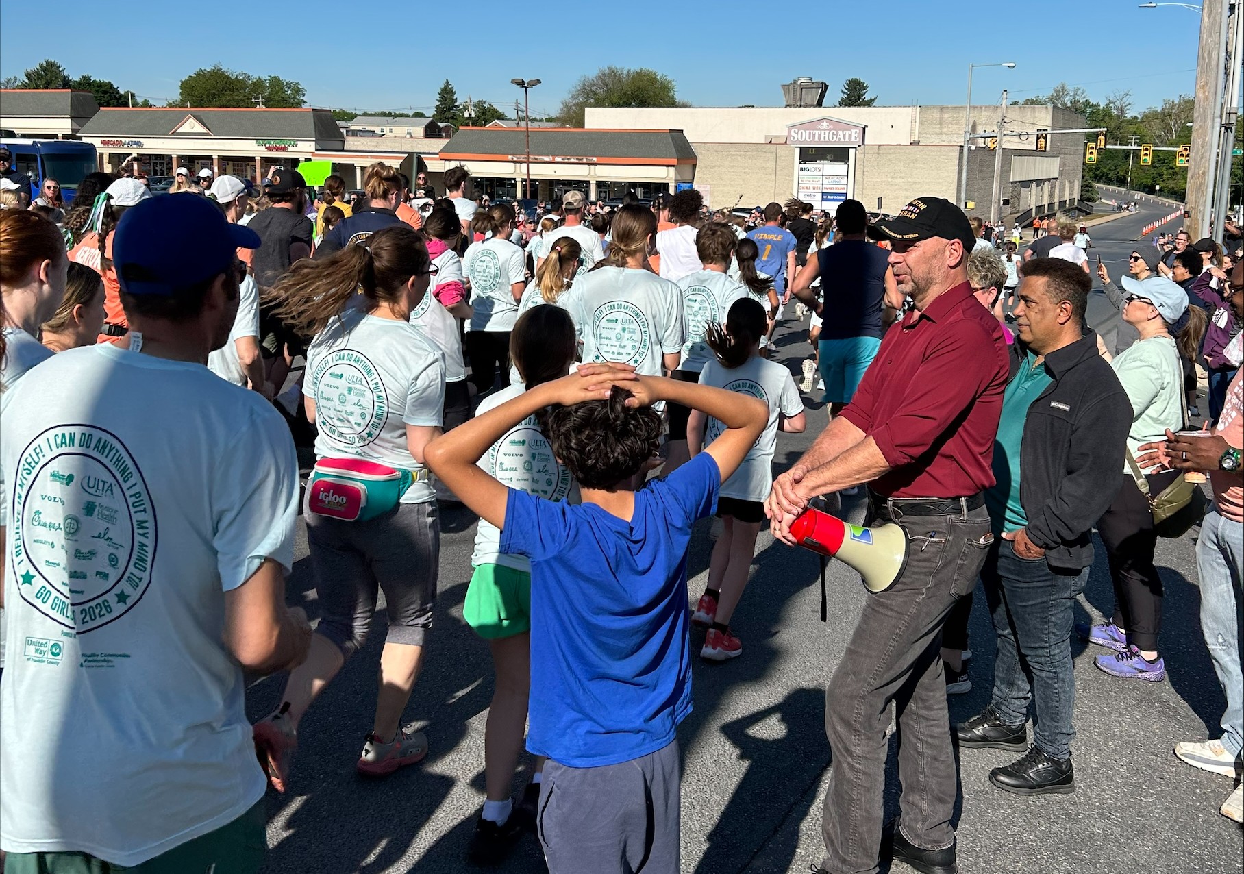 Senator Mastriano standing amongst a large group of kids that just started running a 5K.