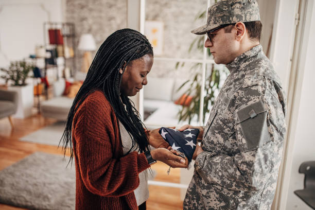 Soldier bringing folded American flag to widow at home, to say her that she has lost her husband in the army war